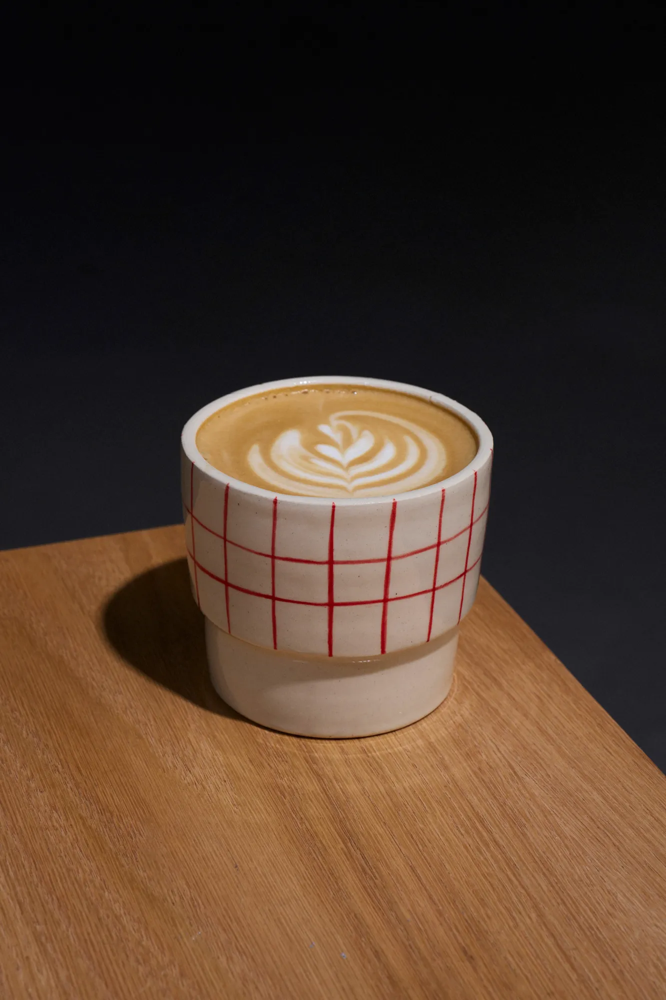 Café latte servido sobre una mesa de Café Tape